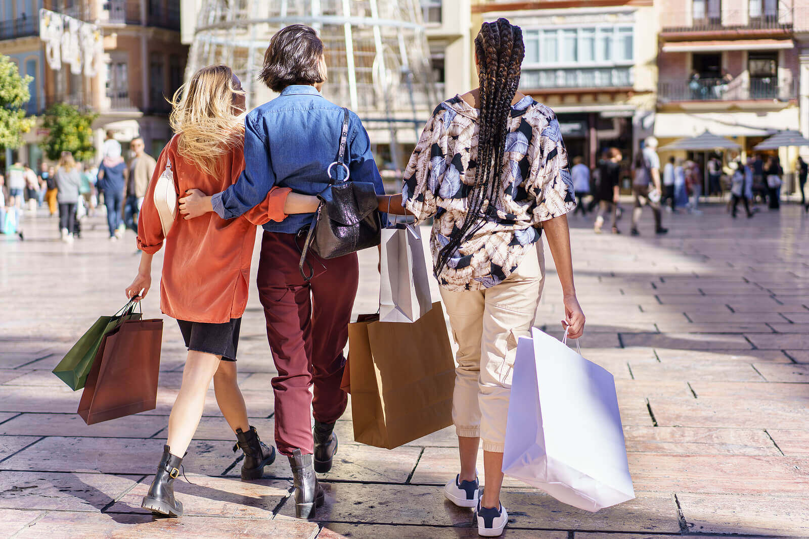 Group of three people with shopping bags in their hands. Looking to move forward from social anxiety in Evanston, IL? Begin social anxiety treatment today and learn to control your anxiety. 