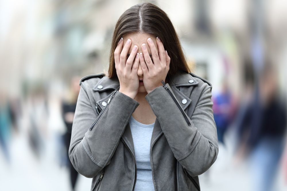 A stressed woman holds her face while the background is blurred. Has anxiety taken over your life? Our therapy for anxiety in Evanston, IL can help you become a better you. Visit us today!