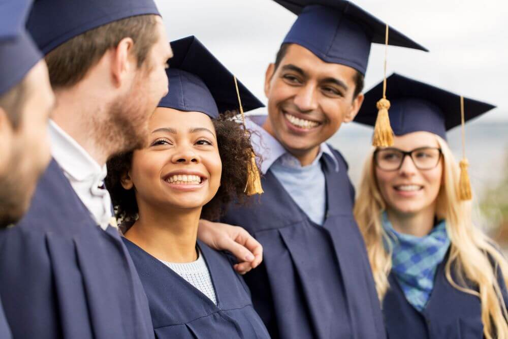 Happy college students at graduation. The photo represents how therapy for college students can help manage anxiety and stress and get students to the finish line. With therapy for college students, you can reduce your stress and anxiety too. Evanston IL | 60603, 60201