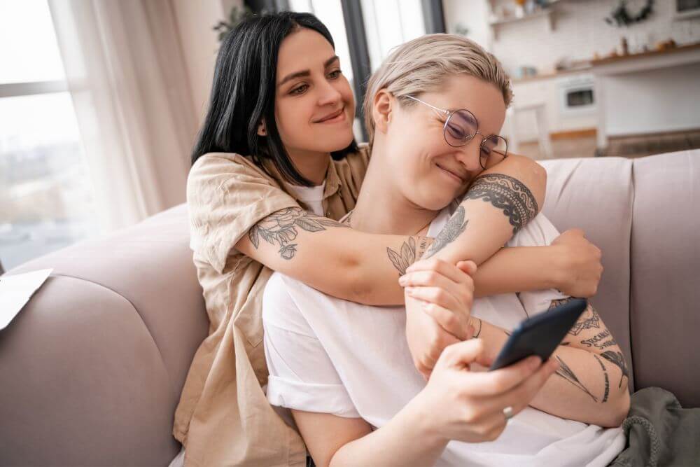 Happy couple snuggling on the couch. The photo represents how therapy for couples and marriage counseling in Evanston IL can help restore your relationship. Evanston Counseling | 60201