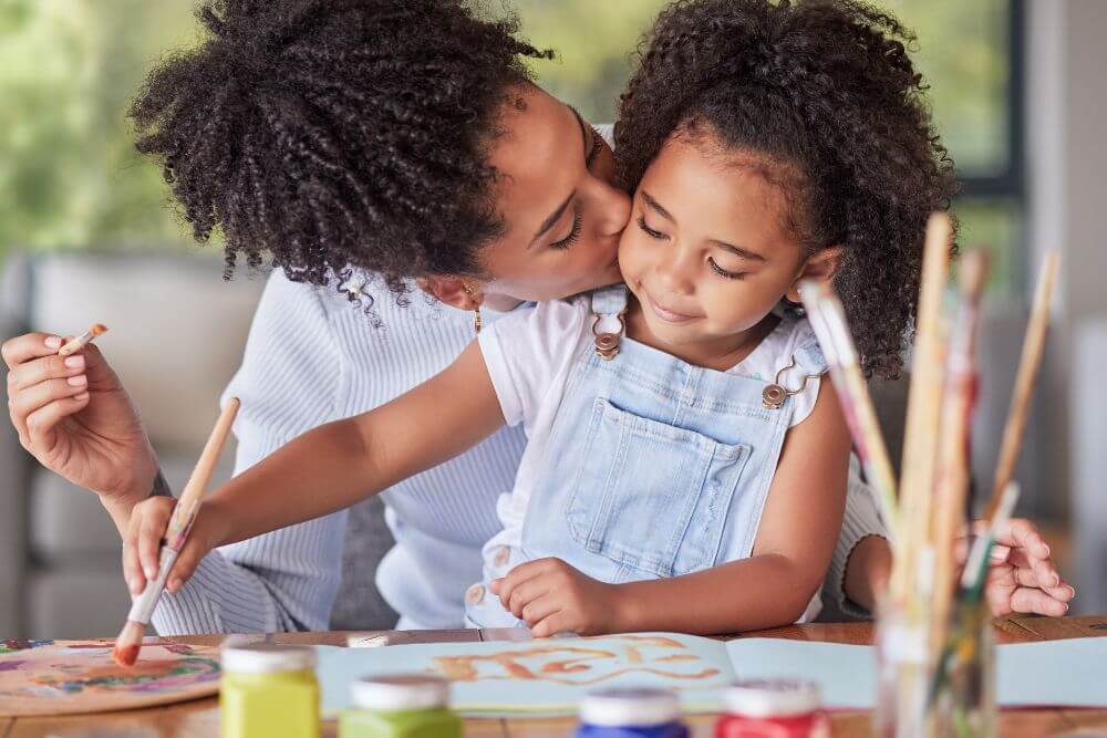Happy mom painting with her child. The photo represents the benefits of reducing anxiety and overwhelm through therapy for moms in Evanston IL | 60201