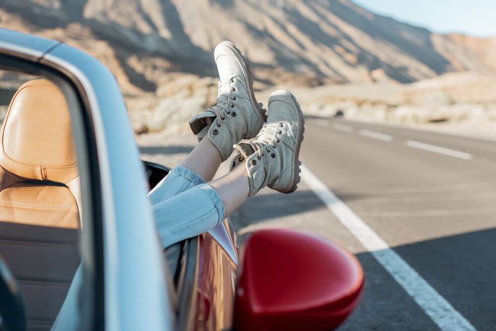 A woman’s legs hang outside of a moving car. Looking to move forward in your life but still have challenges stopping you? Begin therapy for college students in Evanston, IL. Speak with a therapist for college students in Illinois to get the help you need today!
