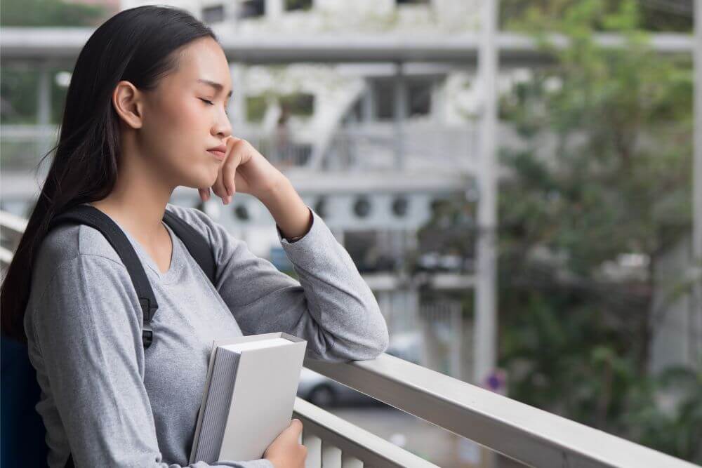 A stressed college girl with her eyes closed. Is college stressing you out? Start therapy for college students in Evanston, IL. Let a therapist for college students in Illinois help relieve that stress today!