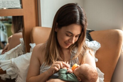 New mom holding infant | Every new mom needs support. You can find support in Evanston or online. Our Evanston Therapists are also here to help you.