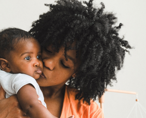 Mother showing infant affection. Woman with strong maternal mental health after therapy in Evanston. Get the support a new mom needs from therapists in Evanston