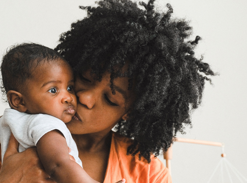 Mother showing infant affection. Woman with strong maternal mental health after therapy in Evanston. Get the support a new mom needs from therapists in Evanston