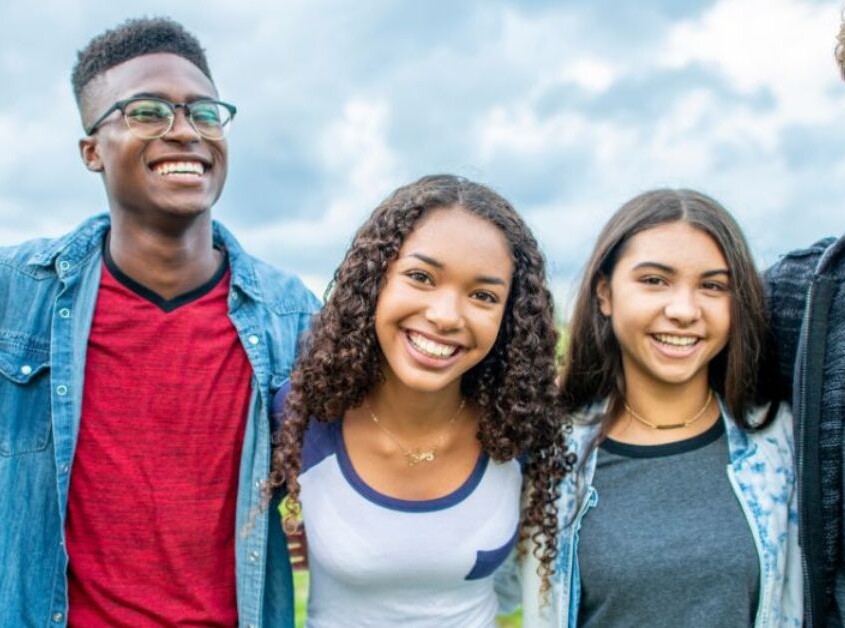A group of teenagers smiling together. Looking to get your teen into Online Therapy for Teenagers in Evanston, IL? Speak with a therapist for teens in Illinois today!