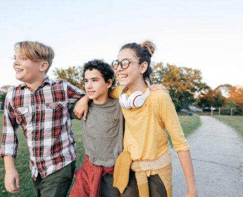 A group of teens walk together outside in a park. Want to help your teen develop in a healthy way? Speak with a teen therapist to learn how Therapy for Teenagers in Evanston, IL helps!