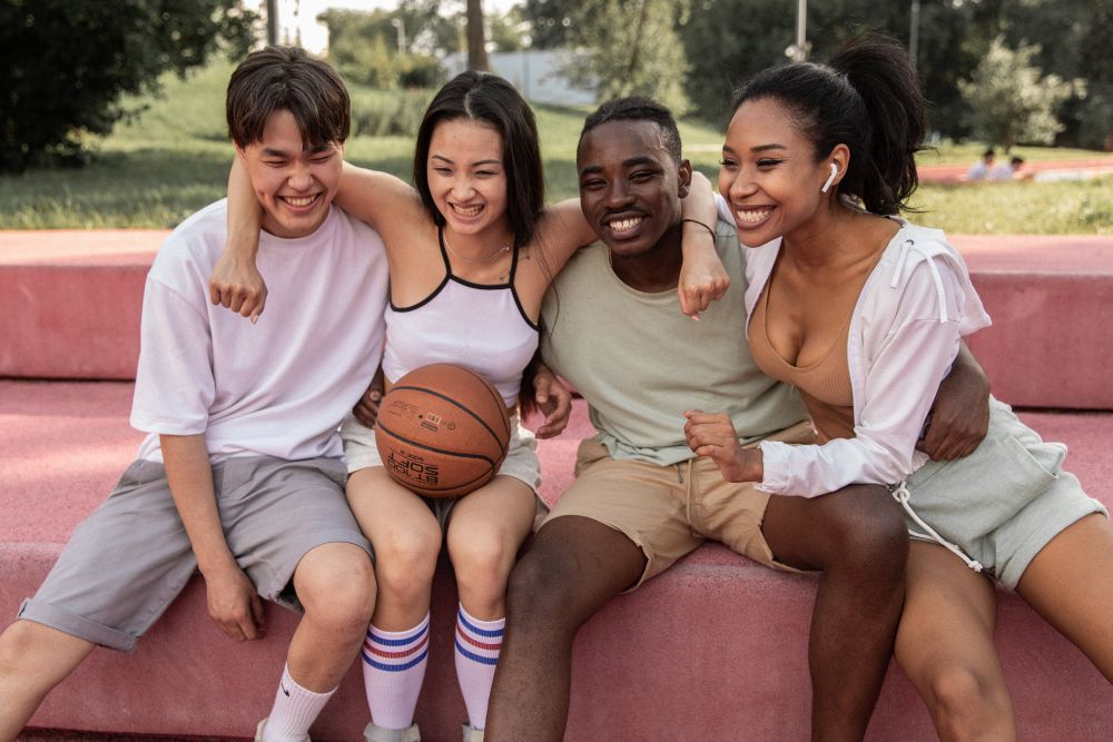 A group of athletic teens smiling. Want to know how Therapy for Teenagers in Illinois can help you with teenage anxiety? Speak with a therapist for teens in Evanston, IL today!