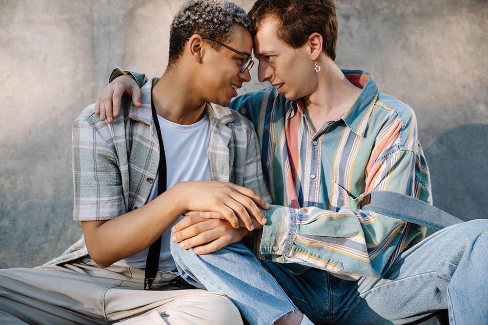 Two Men Touch Heads Together. Looking for LGBTQ+ Affirmative Therapy in Evanston, IL? Speak with an LGBTQ+ Affirming therapist in Illinois today to see how therapy can help!