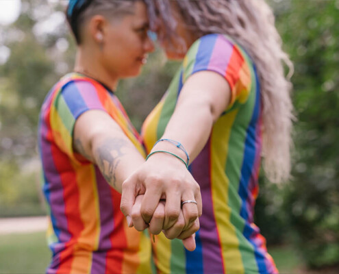 Two women hold hands while touching heads and looking at each other. Are you seeking LGBTQ+ Affirmative Therapy in Evanston, IL? An LGBTQ+ affirming therapist can help you today!