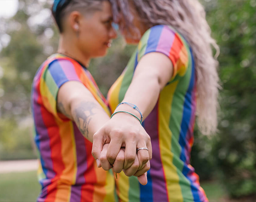 Two women hold hands while touching heads and looking at each other. Are you seeking LGBTQ+ Affirmative Therapy in Evanston, IL? An LGBTQ+ affirming therapist can help you today!