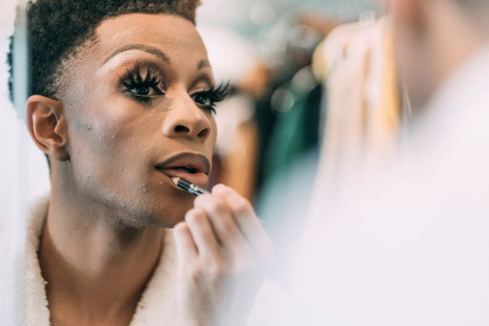 A young man puts on makeup while looking in the mirror. Want to live your most authentic self? It might be time to seek out LGBTQ+ Affirmative Therapy in Evanston, IL. Speak with an LGBTQ+ Affirming therapist today to learn more!