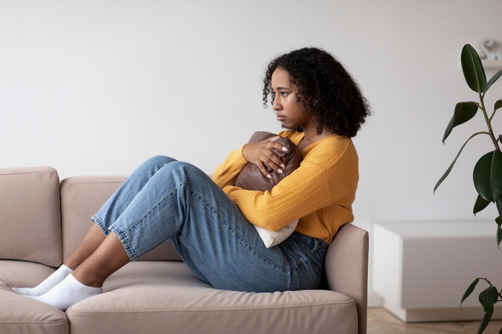 Stressed young woman sitting on the couch. Trying to move past anxiety or stress? It might be time to seek out Cognitive Behavioral Therapy in Evanston, IL. Speak with an CBT therapist in Evanston today to see if it is right for you!