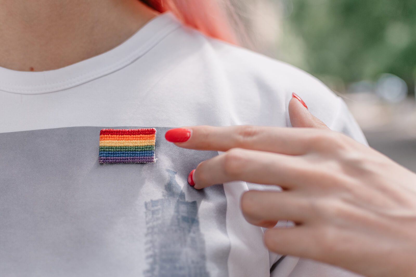 A woman pointing at an LGBTQIA+ pin she is wearing. Trying to work past your LGBTQ+ trauma through LGBTQ+ Affirming therapy in Evanston, IL? Speak with an LGBTQIA+ affirming therapist who can help you today!
