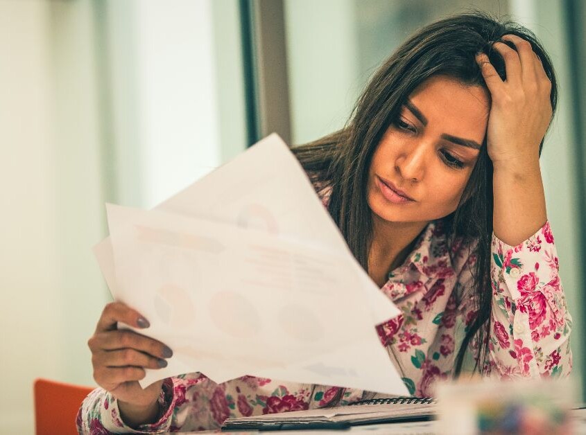 A woman sits and looks at pieces of papers. Wondering how an anxiety therapist in Evanston, IL can help you deal with your anxiety? Learn more about therapy for anxiety in Illinois to see how it can help.