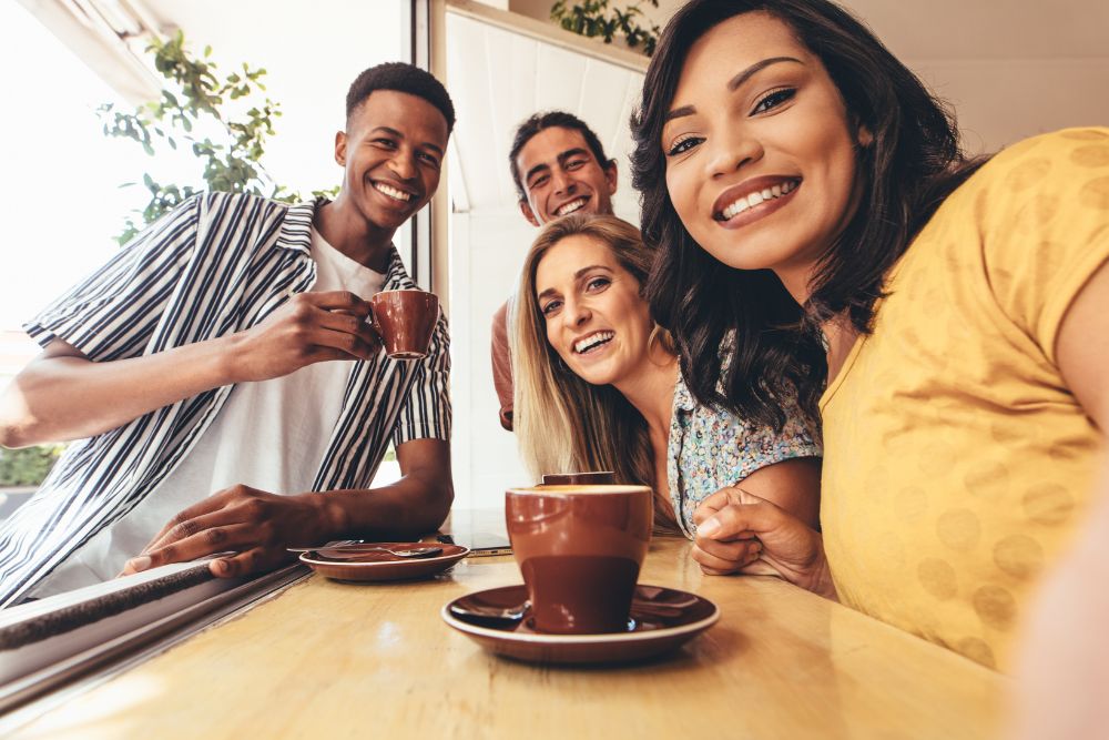 A group of young adults having fun in a cafe. Want to better manage life transitions in Evanston, IL especially after college at Northwestern? It might be time to seek out a therapist for college students in IL. 