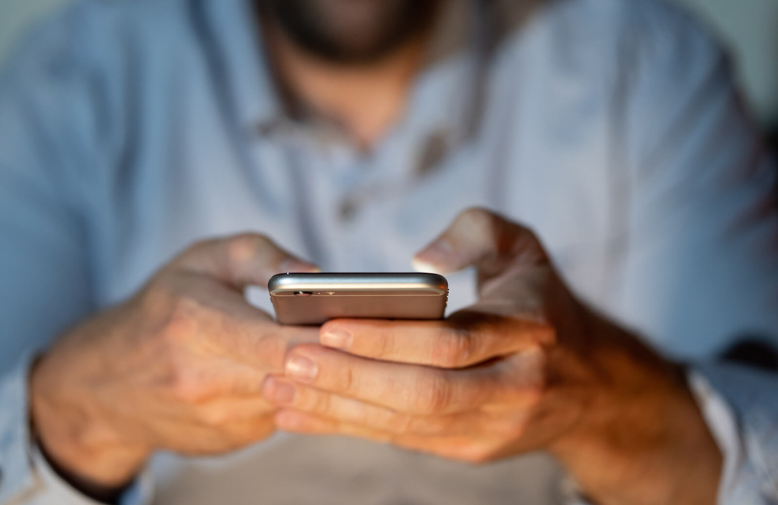 A man uses his cell phone. Want to look into mental health resources in Evanston, IL but do not know where to start? Speak with a therapist at Evanston Counseling today!