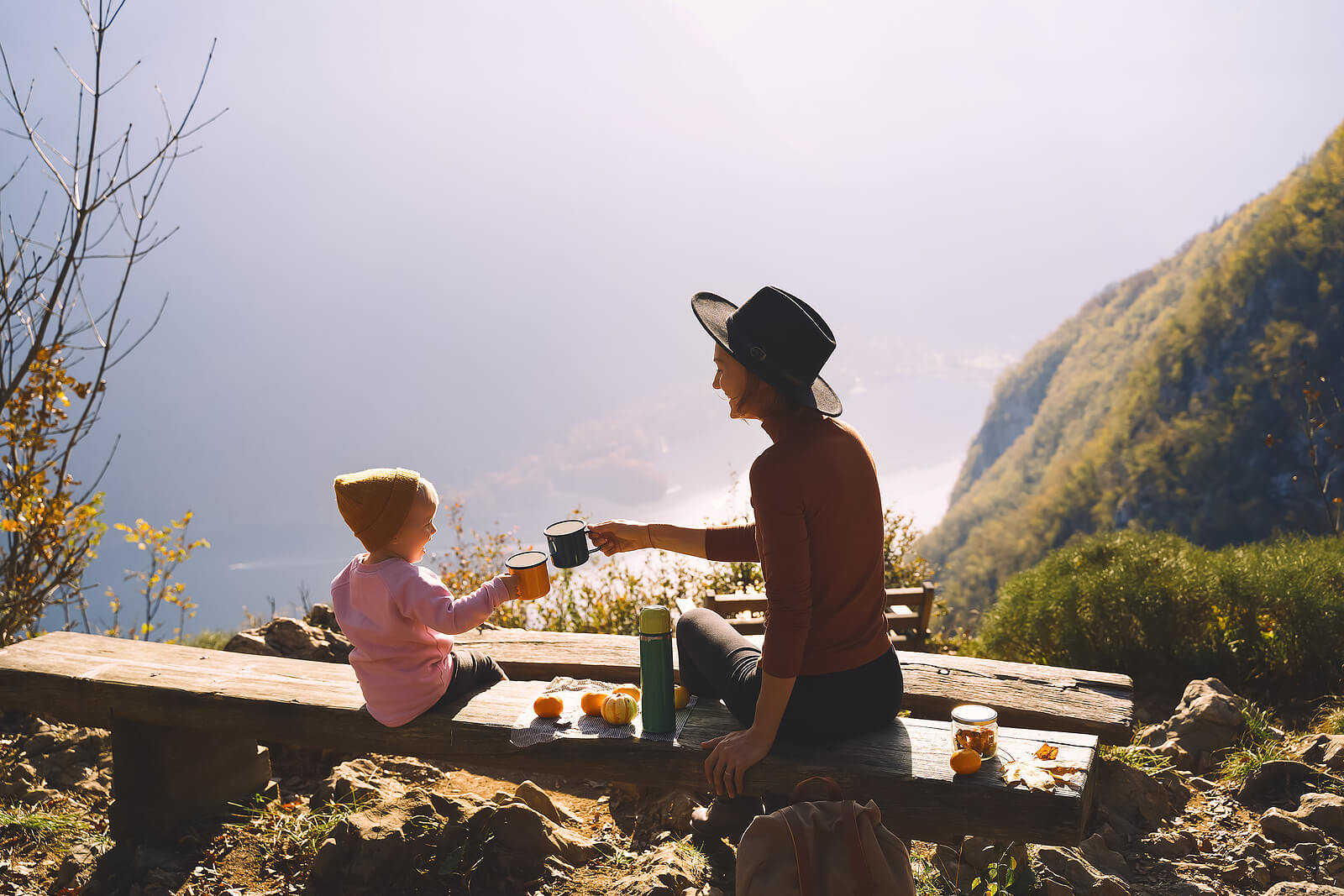 A mom sits on a bench near a cliff with her daughter. Want to learn new ways to navigate motherhood? It might be time to seek Therapy for Moms in Evanston, IL, speak with a therapist for moms today!