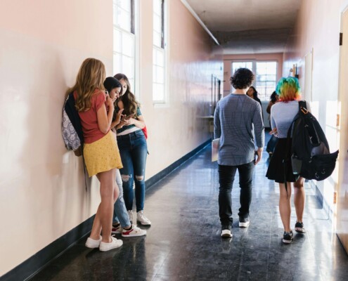 High school students walking and talking in a hallway, capturing the social pressures of senior year—support is available through therapy for teens in Chicago, IL and from a therapist for teens in Evanston, IL.