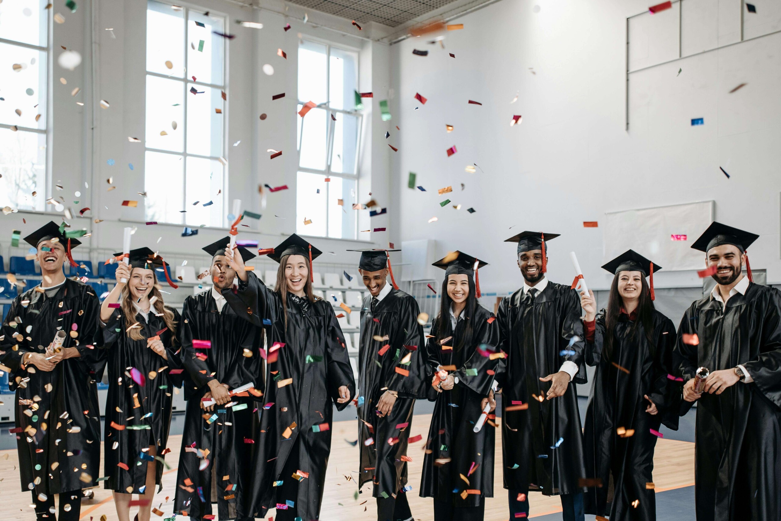 Graduating College Students | evanston psychologists | social anxiety in college evanston | social anxiety in college evanston | therapist for college students in chicago, il | Lincoln Park, IL | Downtown Evanston, IL | Central Street District, IL Group of joyful graduates celebrating with colorful confetti in a bright indoor setting, symbolizing achievement. Perfect for a blog on online college counseling in Chicago, IL, and Evanston psychologists helping students succeed.