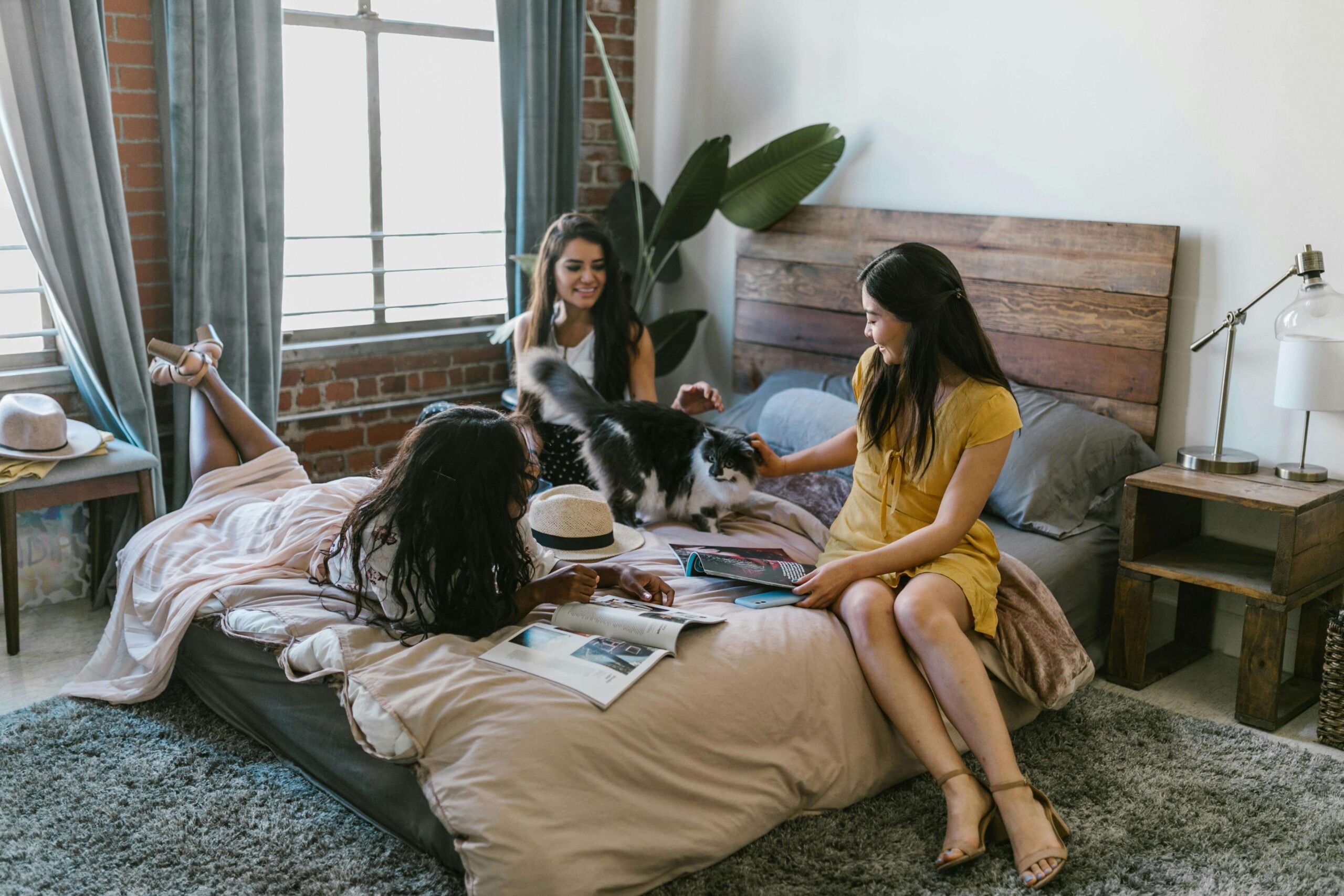 Three college students relaxing and studying together in a cozy apartment bedroom, highlighting the importance of peer connection and support when working with a young adult therapist in Illinois and seeking therapy for college students in Chicago, IL.