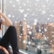 Teen sitting by a window with snow falling outside, looking overwhelmed during the holidays—an example of why cognitive behavioral therapy in chicago, il, cbt for anxiety in evanston, il, and a cbt therapist in evanston, il can help.