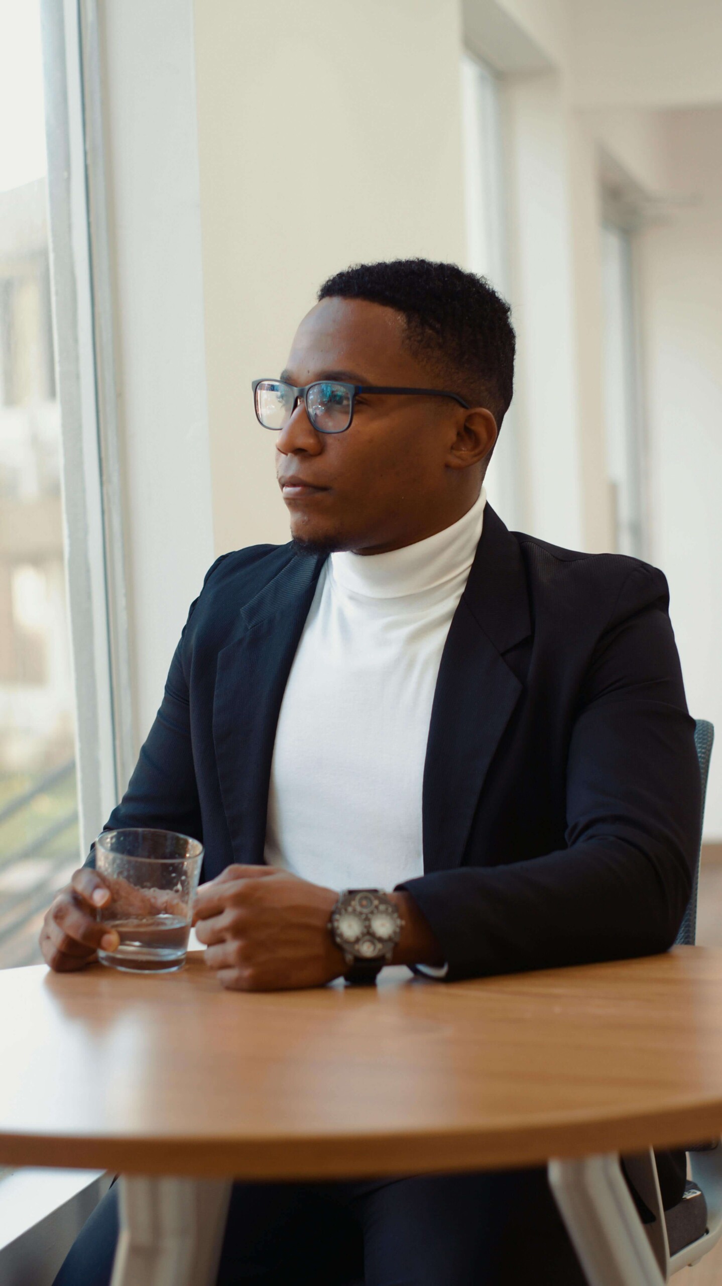 A college student in professional attire sitting alone with a contemplative expression, symbolizing the disconnect of functional depression that can be addressed through therapy for college students in Chicago, IL with a therapist for college students in Chicago, IL.