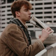 A college student in a tan jacket reading outdoors, representing the introspective journey of addressing functional depression through online therapy for college students in Chicago, IL and cognitive behavioral therapy in Chicago, IL.
