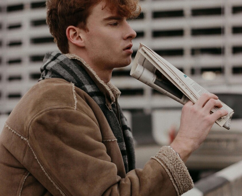 A college student in a tan jacket reading outdoors, representing the introspective journey of addressing functional depression through online therapy for college students in Chicago, IL and cognitive behavioral therapy in Chicago, IL.