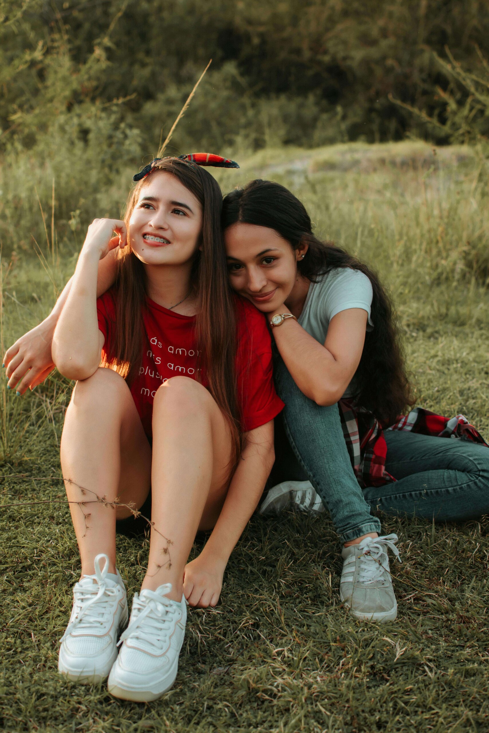 Two teen girls sitting close together outdoors, representing the meaningful friendships that can shift during high school—a challenge addressed through therapy for teens in Chicago, IL and cognitive behavioral therapy in Chicago, IL.