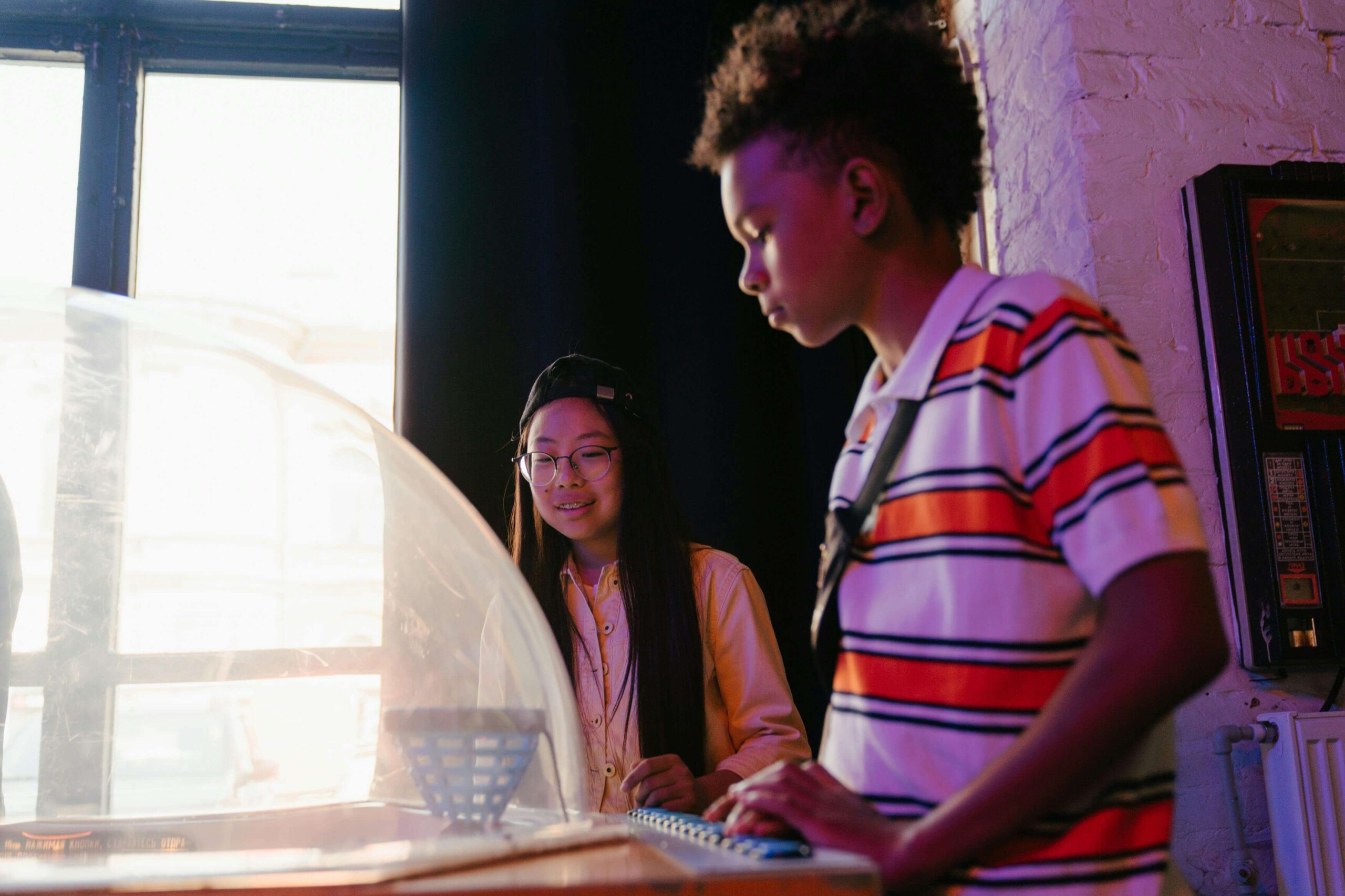 Two teens working together on a computer in a bright space, representing genuine connection beyond the curated performance of social media—supported through therapy for teens in Chicago, IL and cognitive behavioral therapy in Chicago, IL.