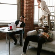 Three college roommates relaxing in their shared apartment, representing the dynamic relationships that can be supported through counseling for college students in Chicago with guidance from a therapist for college students in Chicago, IL.