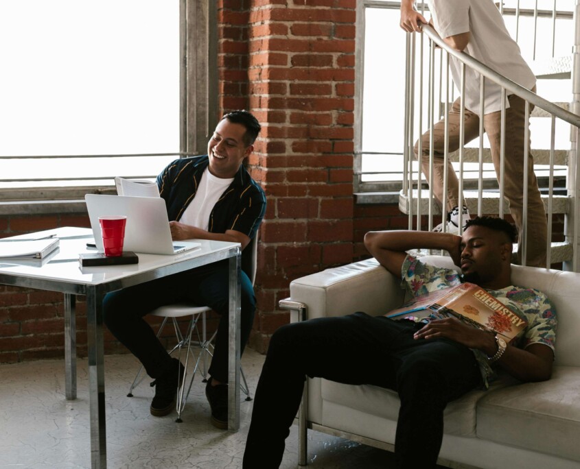 Three college roommates relaxing in their shared apartment, representing the dynamic relationships that can be supported through counseling for college students in Chicago with guidance from a therapist for college students in Chicago, IL.