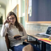 A college student studying at a desk with books and laptop, appearing thoughtful and focused—representing the experience of managing academic stress that can be supported through counseling for college students in Chicago with guidance from a therapist for college students in Chicago, IL.