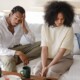 A couple sitting on a couch looking distressed and disconnected, representing the emotional strain that can be addressed through couples therapy in Evanston, IL with support from a couples therapist in Evanston, IL.