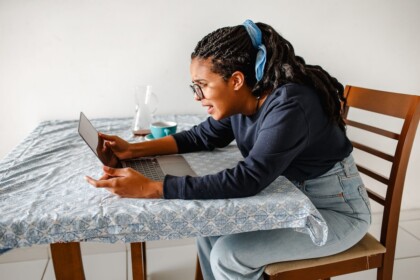 Arguing On FaceTime | therapy for college students in evanston, il | therapist for college students in evanston, il | goals for college evanston | online therapy in illinois | Rogers Park, IL | Streeterville, IL | Northwestern University, IL A college student sitting at a table looking frustrated during a video call on her laptop, illustrating the tension of long-distance relationship conflicts that can be addressed through therapy for college students in Evanston, IL with support from a therapist for college students in Evanston, IL.