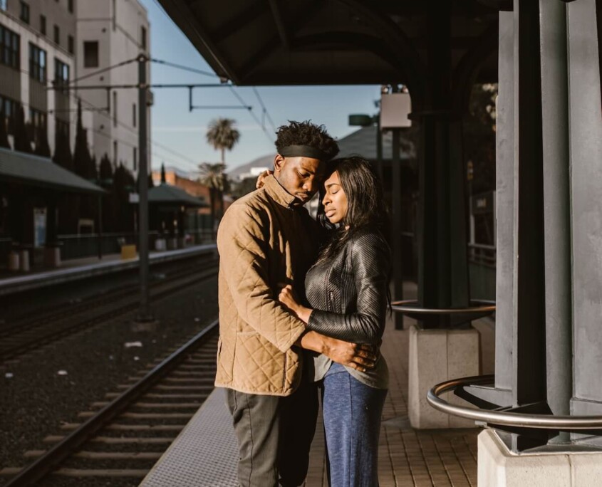 A young couple sharing a quiet moment on a train platform before parting ways, representing the emotional weight of long-distance relationships that can be supported through therapy for college students in Evanston, IL with guidance from a therapist for college students in Evanston, IL.